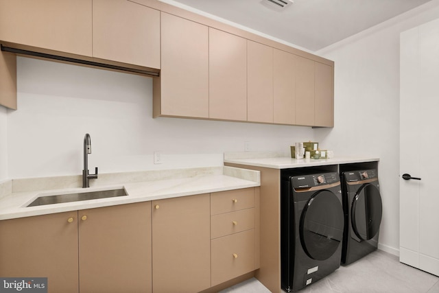 laundry area featuring a sink, washing machine and clothes dryer, and cabinet space