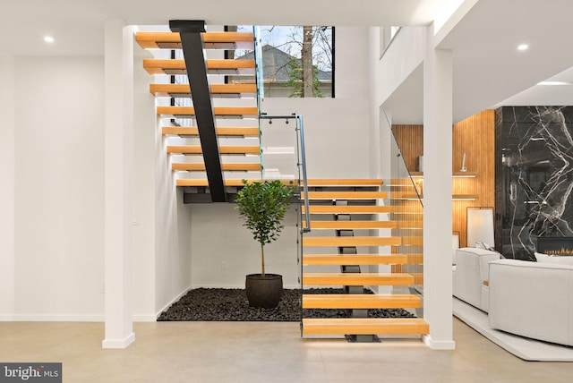 stairs featuring a high ceiling, baseboards, and recessed lighting