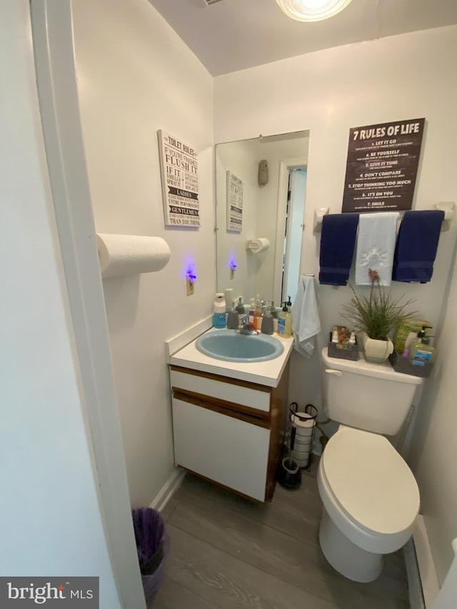 bathroom with vanity, wood finished floors, and toilet