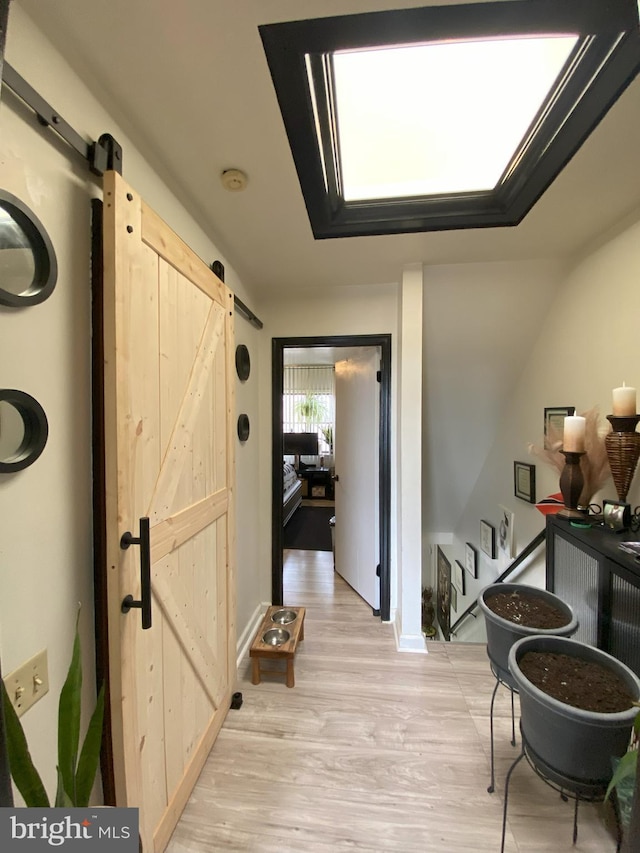 hallway featuring a barn door and light wood-type flooring