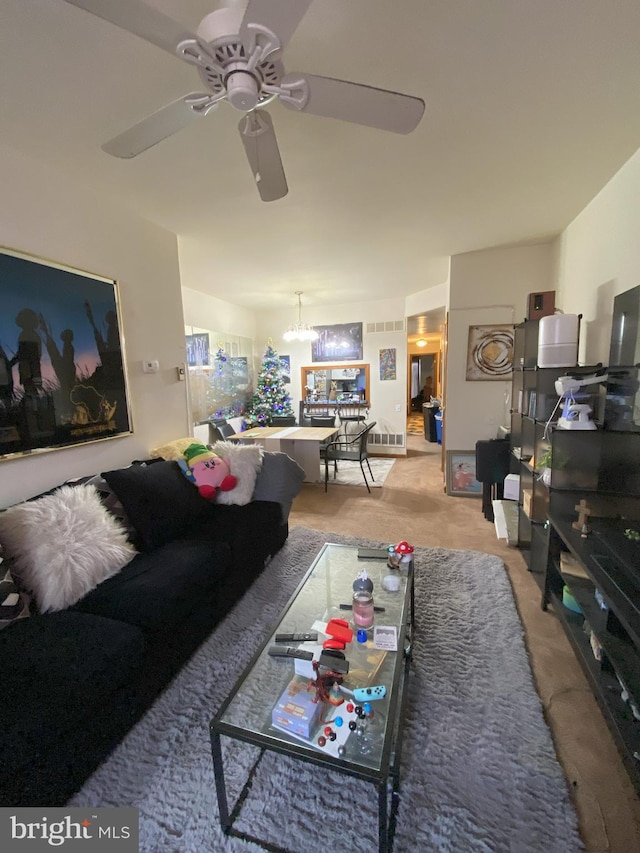 living room with visible vents, a ceiling fan, and light colored carpet