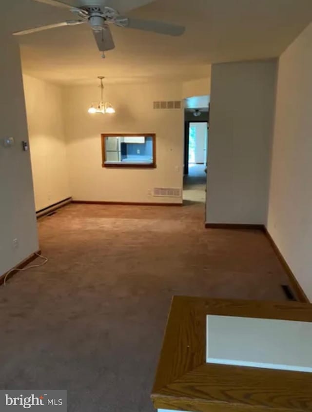 unfurnished living room featuring ceiling fan with notable chandelier, visible vents, and baseboards