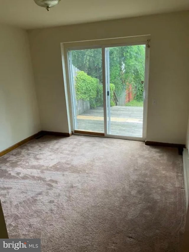 carpeted spare room with baseboards