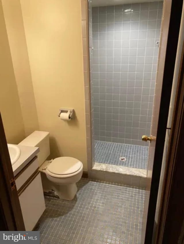 full bathroom with a stall shower, vanity, toilet, and tile patterned floors