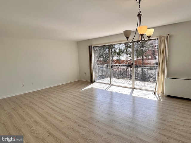 unfurnished dining area with a chandelier, baseboards, and wood finished floors