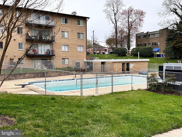 pool featuring a lawn and fence