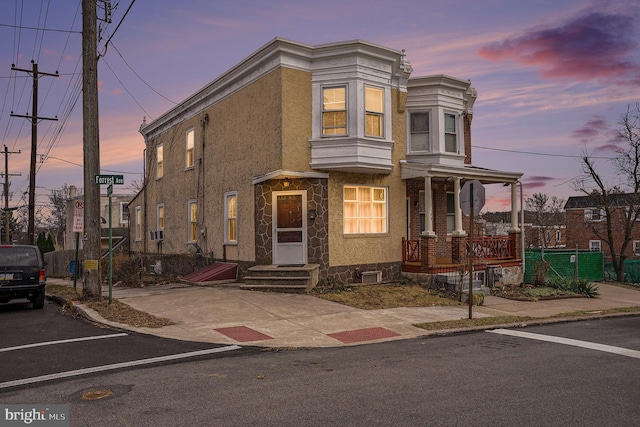 view of property with entry steps, a porch, and stucco siding