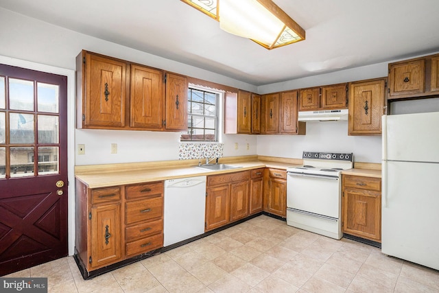 kitchen with under cabinet range hood, a sink, white appliances, brown cabinetry, and light countertops