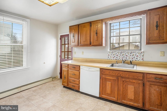 kitchen featuring dishwasher, light countertops, baseboard heating, brown cabinetry, and a sink