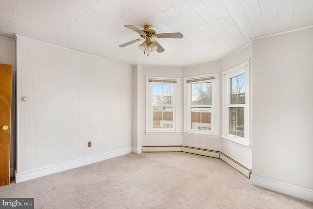 spare room featuring baseboards, ceiling fan, ornamental molding, carpet flooring, and baseboard heating