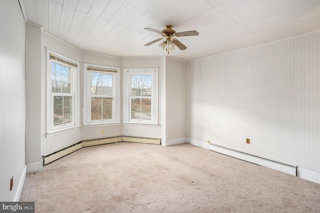 carpeted spare room featuring crown molding, a ceiling fan, and a baseboard radiator