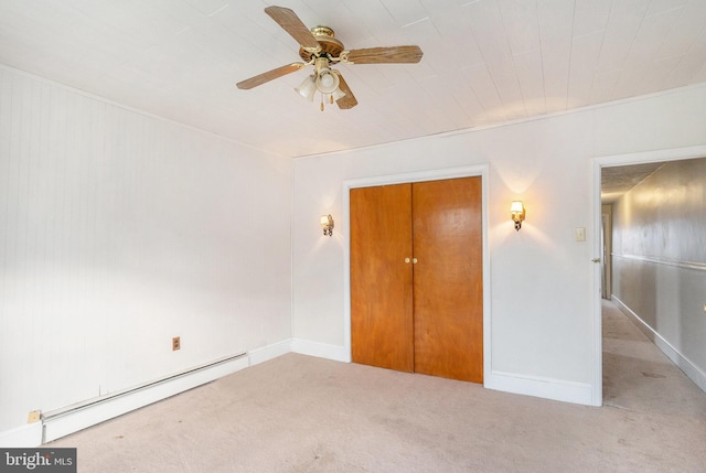 unfurnished bedroom with baseboard heating, baseboards, a ceiling fan, and carpet floors