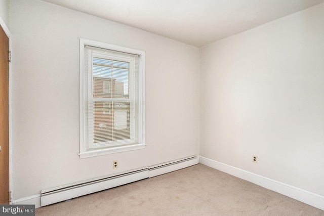 empty room with a baseboard heating unit, baseboards, and carpet flooring