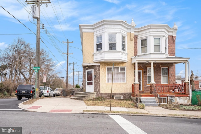 townhome / multi-family property featuring brick siding and covered porch