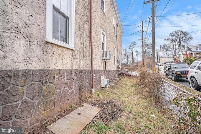 view of property exterior featuring fence and stucco siding