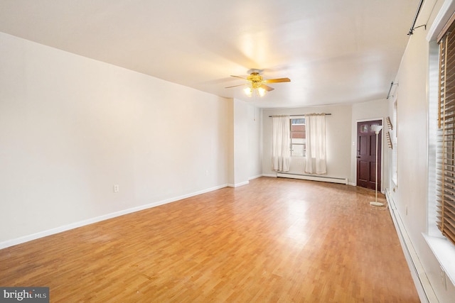 unfurnished room featuring a baseboard heating unit, baseboards, light wood-style floors, and a ceiling fan