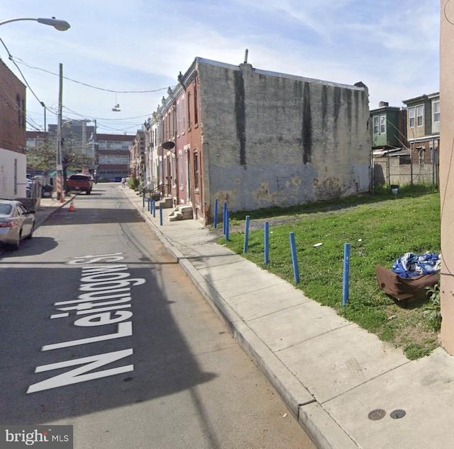 view of road featuring sidewalks, curbs, and street lights