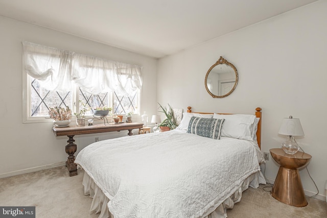 bedroom with light carpet and baseboards