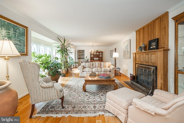 living area with a fireplace, wood finished floors, and ornamental molding