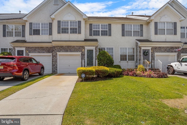 view of property with an attached garage, stone siding, a front lawn, and concrete driveway