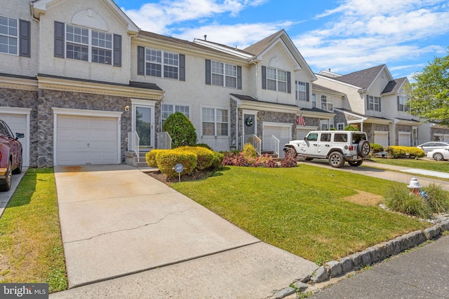 multi unit property with a garage, concrete driveway, and stone siding