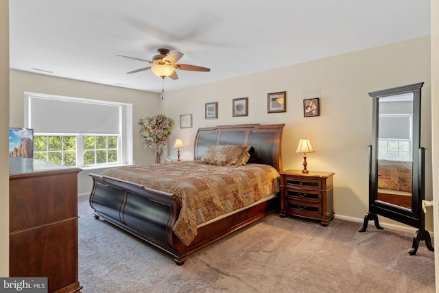 carpeted bedroom with a ceiling fan, visible vents, and baseboards