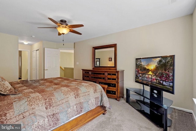 carpeted bedroom with a closet, baseboards, and a ceiling fan