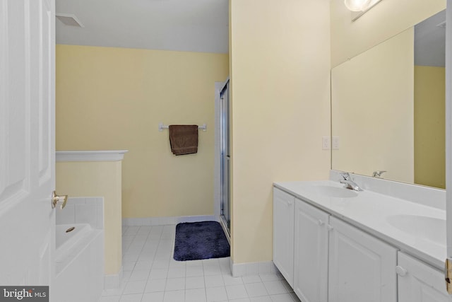 bathroom with baseboards, a sink, a bath, and tile patterned floors