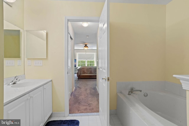 ensuite bathroom featuring baseboards, ensuite bathroom, tile patterned floors, a garden tub, and vanity