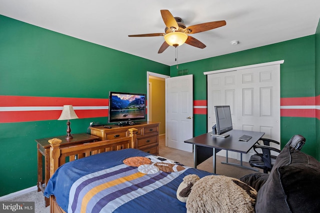 bedroom featuring a closet, light carpet, ceiling fan, and baseboards