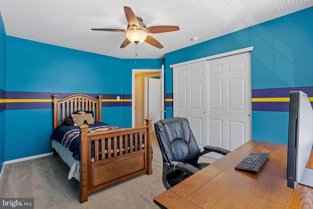 carpeted bedroom with ceiling fan, a closet, and baseboards