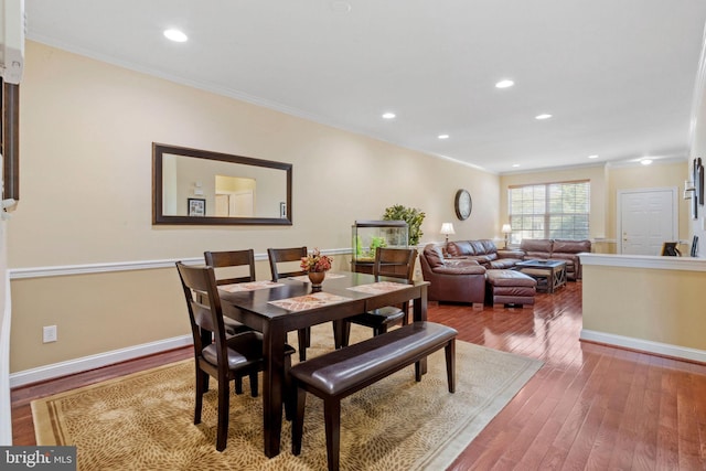 dining space featuring baseboards, hardwood / wood-style floors, recessed lighting, and crown molding