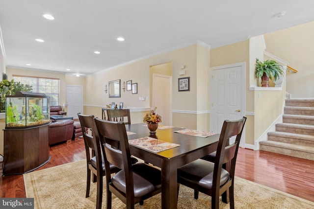 dining room with recessed lighting, wood finished floors, baseboards, stairway, and crown molding