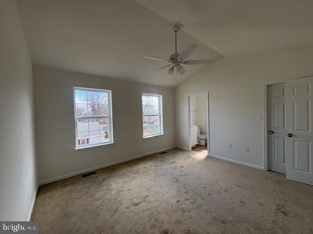 unfurnished bedroom featuring carpet, baseboards, visible vents, vaulted ceiling, and ensuite bathroom