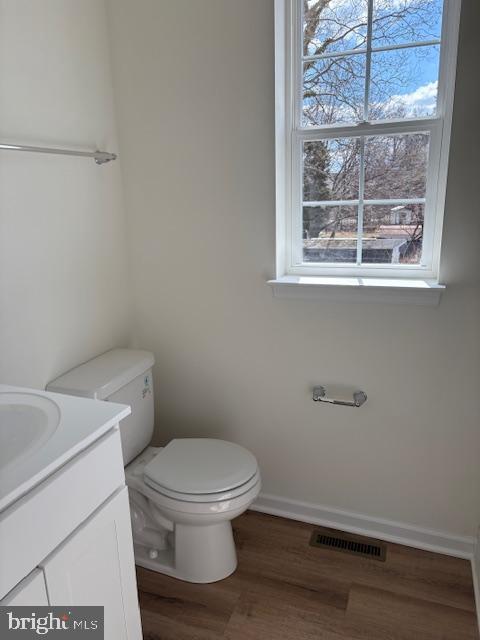 bathroom with visible vents, a healthy amount of sunlight, toilet, and baseboards