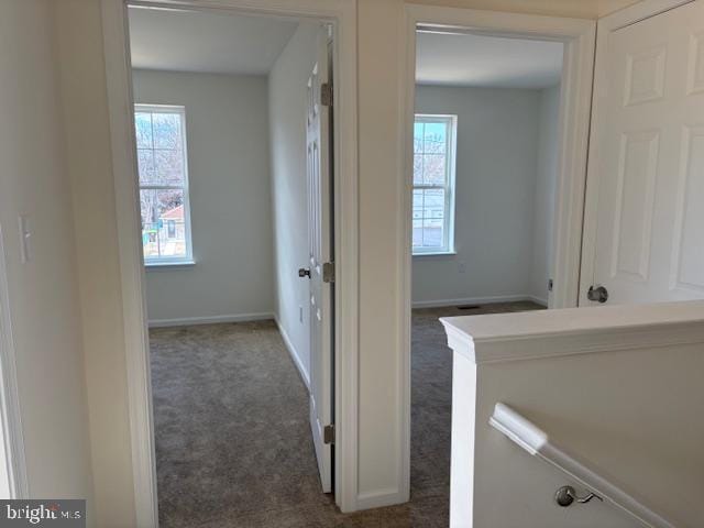 corridor with carpet flooring and baseboards