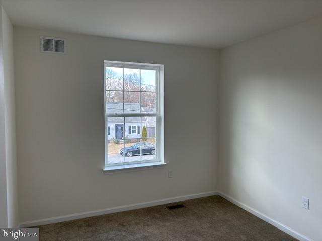 unfurnished room featuring visible vents, baseboards, and carpet flooring