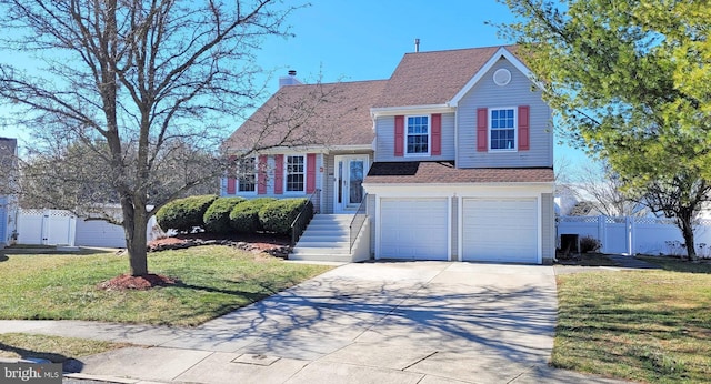 tri-level home featuring a front yard, concrete driveway, fence, and a chimney