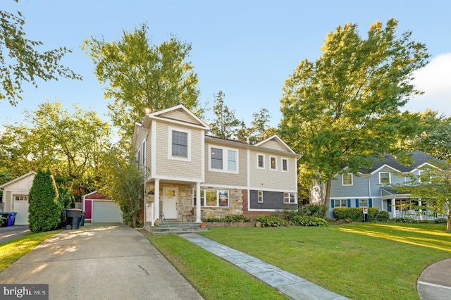 view of front of home featuring stone siding, a detached garage, and a front lawn