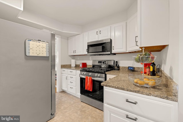 kitchen with light tile patterned floors, appliances with stainless steel finishes, and white cabinets