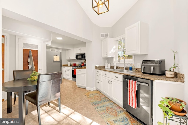 kitchen with stainless steel appliances, a sink, visible vents, white cabinets, and vaulted ceiling