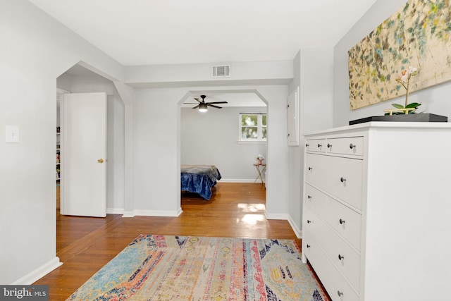 bedroom with baseboards, visible vents, and wood finished floors