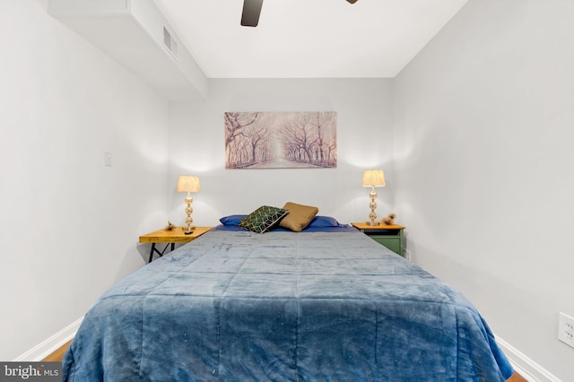 bedroom featuring visible vents, wood finished floors, a ceiling fan, and baseboards