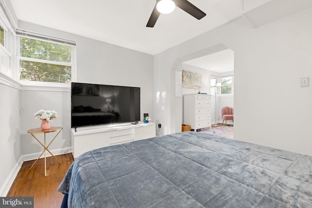 bedroom with ceiling fan, baseboards, and wood finished floors