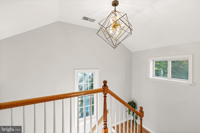 stairs featuring vaulted ceiling, a chandelier, visible vents, and baseboards