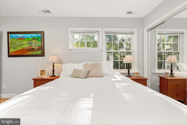 bedroom with multiple windows, a closet, and visible vents