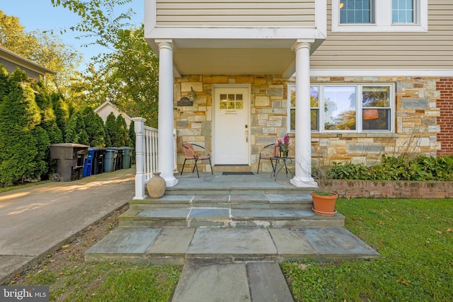 entrance to property featuring stone siding and covered porch