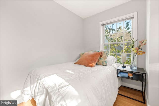 bedroom with baseboards and wood finished floors