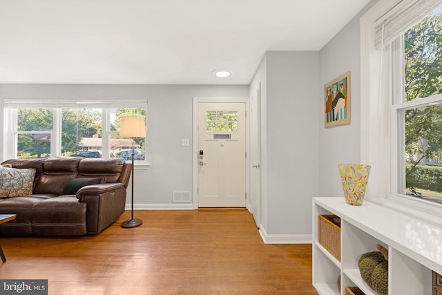 interior space with wood finished floors, visible vents, and a healthy amount of sunlight