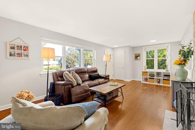 living area with light wood-style flooring, baseboards, and recessed lighting